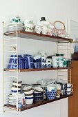 Crockery in various patterns stacked on retro String shelves
