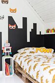 Teenager's attic bedroom with bed on pallets