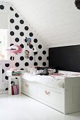 Bed against polka-dot wall in child's bedroom