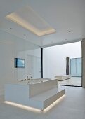Free-standing bathtub with step in white, minimalist designer bathroom with indirect lighting in floor and ceiling
