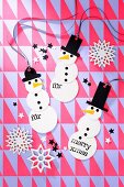 Festive, hand-made snowman decorations on geometric wrapping paper