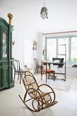 Rattan rocking chair in bright room with sewing machine in background