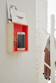 A wooden box painted orange as a mobile charging station