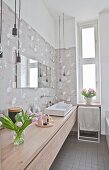 Long washstand and flamingo-patterned wallpaper in bathroom