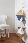 Geometric paper shapes hung from wardrobe door