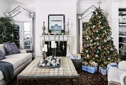 Geschmückter Weihnachtsbaum und verpackte Geschenke in ländlichem Wohnzimmer