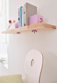 A homemade shelf made of wooden boards stuck together with sliding book ends