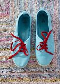 Light blue sneakers with red laces