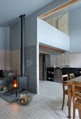 Gallery and kitchen-dining area in double-height interior of old, renovated wooden house