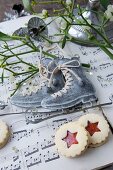 Ice-skate ornaments, mistletoe and biscuits on sheet music