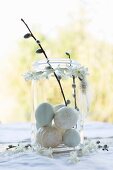 Helle Eier in einem Weckglas mit Weidenkätzchen-Zweigen und Girlande aus Hyazinthenblüten