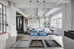 View across hob into living-dining area of industrial loft apartment in shades of grey