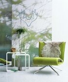 Grüner Sessel mit Fell vor einer Wand mit Fototapete