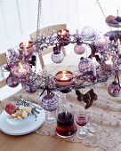 Tealights on festively decorated, suspended metal wreath
