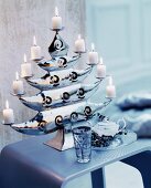 Lit white pillar candles on elegant candle holder shaped like a tree