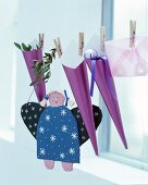 DIY-Adventskalender aus lila Spitztüten an Schnur aufgehängt, und handgefertigte Engelfigur