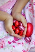 Mädchen hält mehrere Schokoladenostereier in den Händen