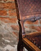 Antique wooden chair in front of brick wall (detail), Restaurant Charango, Cape Town, South Africa
