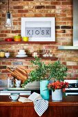 Vases on the kitchen island in front of a brick wall