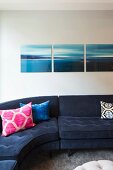 Triptych above blue corner sofa with colourful scatter cushions