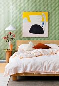 Schlafzimmer mit grün gemusterter Tapete und Holzmöbeln