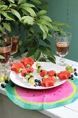 Obstspiesschen auf weißem Teller und DIY-Tischset