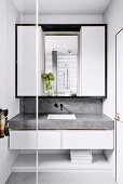 Bathroom installation with marbled vanity top and white wall cabinet with black frame