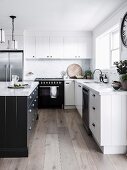 weiße Einbauküche mit schwarzem Küchenblock