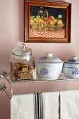 Porcelain bowls and glass jar on wall-mounted metal shelf