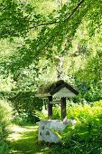 Vintage covered well with mossy wooden roof in garden