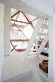 White ladder staircase on landing in converted barn