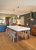 Large dining table and wooden stools in cosy kitchen
