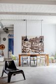 Various chairs in front of large vintage-style photo and view of entrance area in loft apartment