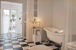 Free-standing bathtub on chequered bathroom floor