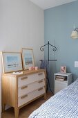 Valet stand between chest of drawers and bedside cabinet in corner of bedroom