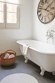 Bad mit freistehender Badewanne und Vintage Wanduhr