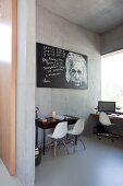Arbeitszimmer mit weissen Stuhlklassikern und Albert Einstein Bild in Betonhaus