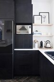 Black fitted kitchen with white worksurface