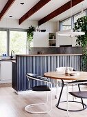 Bright dining area with kitchen counter and visible beams