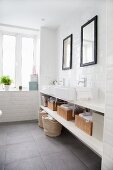White countertop sinks below black-framed mirrors in minimalist bathroom