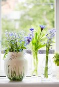 Drei zarte Blumensträußchen in Vasen auf Fenstersims