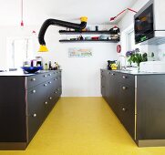 Retro-Küche mit schwarzen Möbeln und gelbem Boden