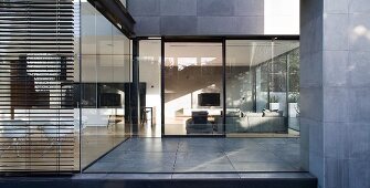 View through glass wall into living room of modern house