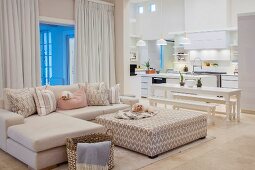 Sofa, dining table and kitchen in white open-plan living room