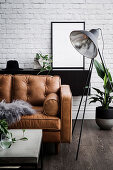 Leather sofa in the masculine living room with brick wall