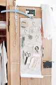 Various sewing accessories and hand-made wire coathangers hung on cupboard door