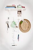 Various accessories hung from hooks below white wall-mounted bracket shelf