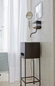 Black metal washstand below vintage-style wall-mounted tap on white mosaic wall tiles