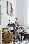 Gilt-framed pictures and storage trays on trolley in boy's bedroom