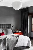 Elegantes Schlafzimmer in Grautönen mit roten Farbakzenten